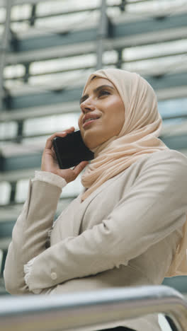 Vertikales-Video-Einer-Muslimischen-Geschäftsfrau-Mit-Mobiltelefon,-Die-Vor-Dem-Büro-In-Der-Stadt-Steht